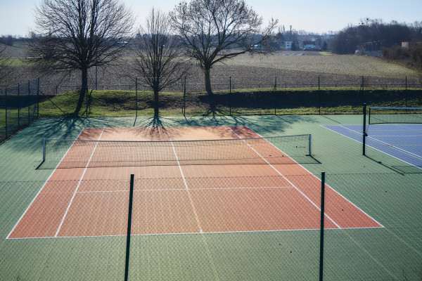 Modularer Tennisplatz einer Kommune im Freien, umgeben von Bäumen